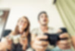 Woman and man sit on sofa with gaming devices